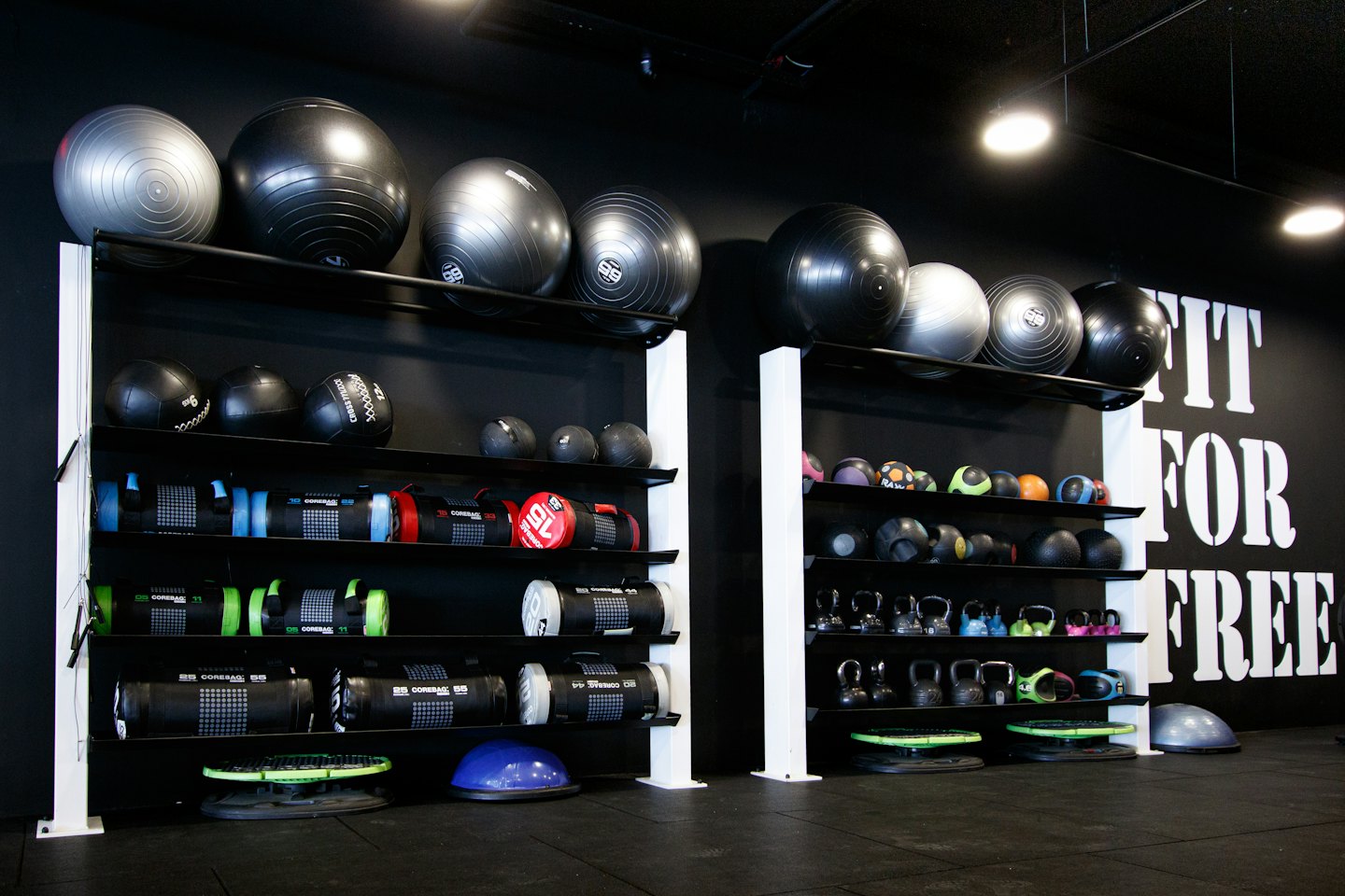 Gym with black shelves holding diverse fitness equipment.