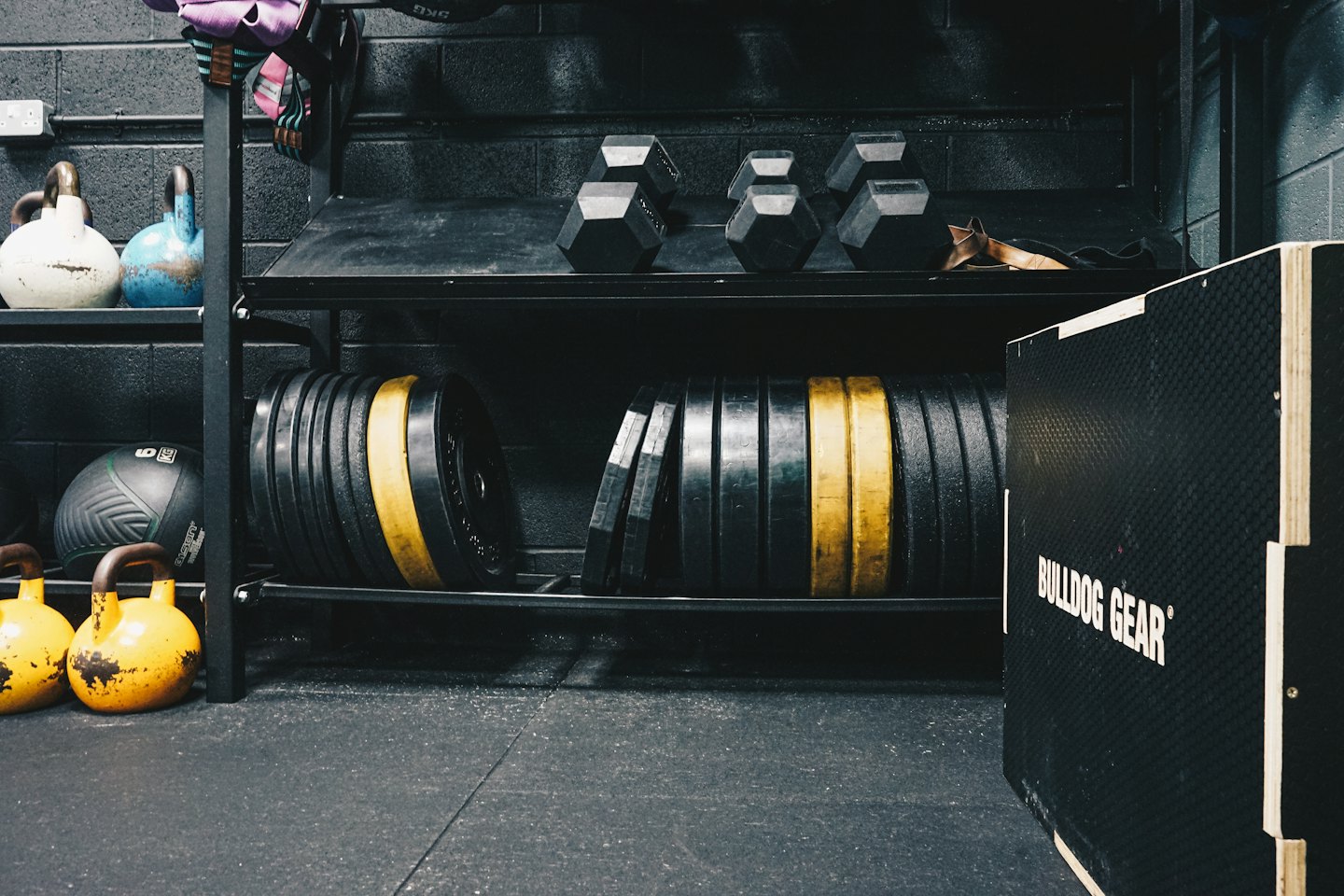 Gym equipment neatly arranged on racks in a fitness facility.